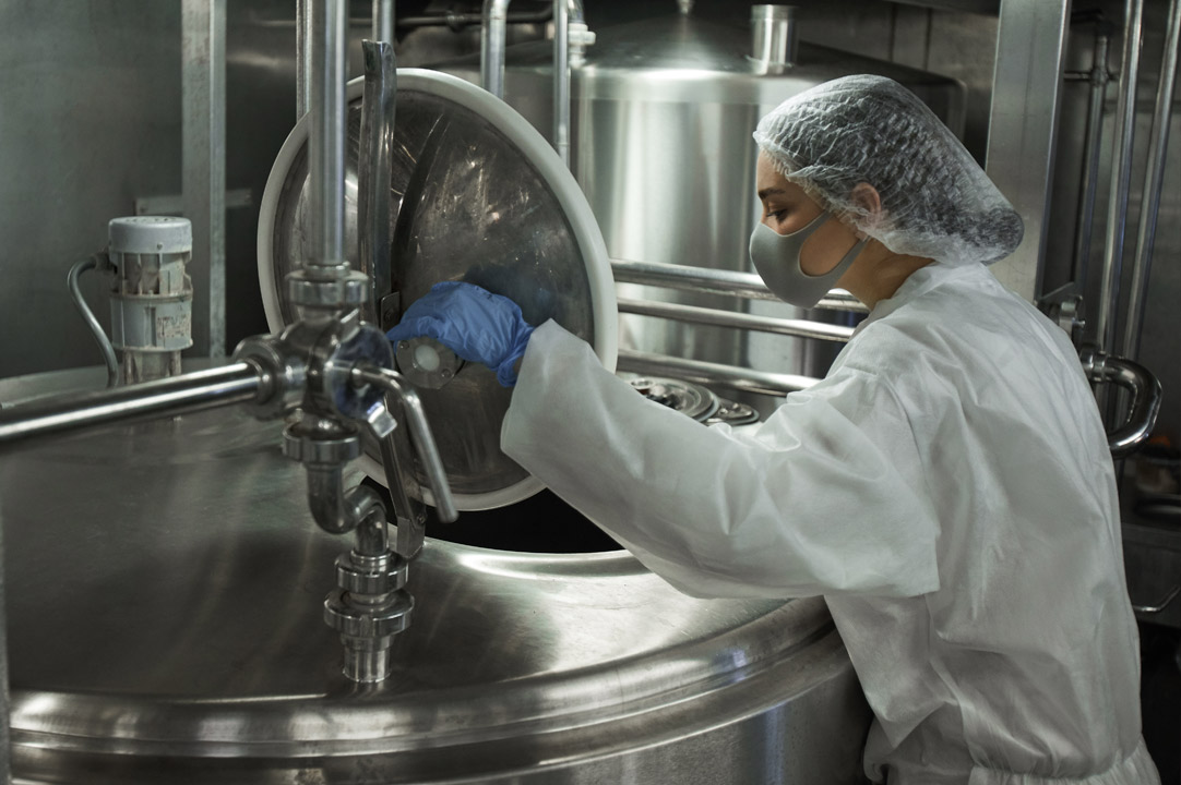 Picture of a woman looking in a big cooking container 